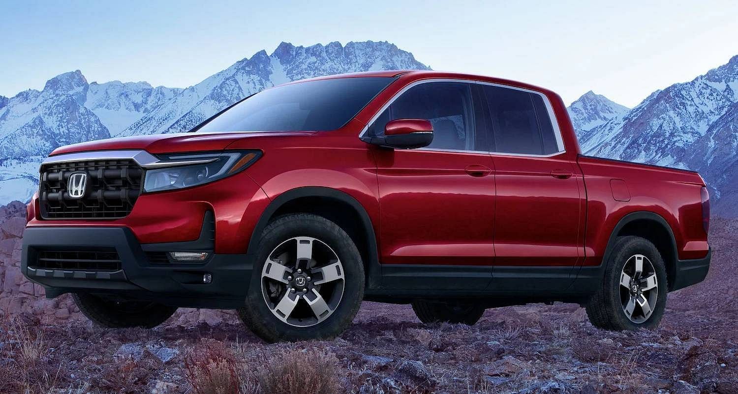 The 2025 Honda Ridgeline RTL in Radiant Red Metallic II parked on a rocky road with snowy mountains in background
