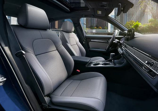 Interior view of the 2025 Honda Civic Hybrid Sport Touring with gray leather-trimmed seats and a modern, ergonomic dashboard.