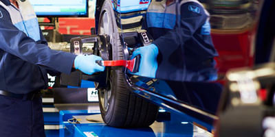Mechanic working on wheel alignment 