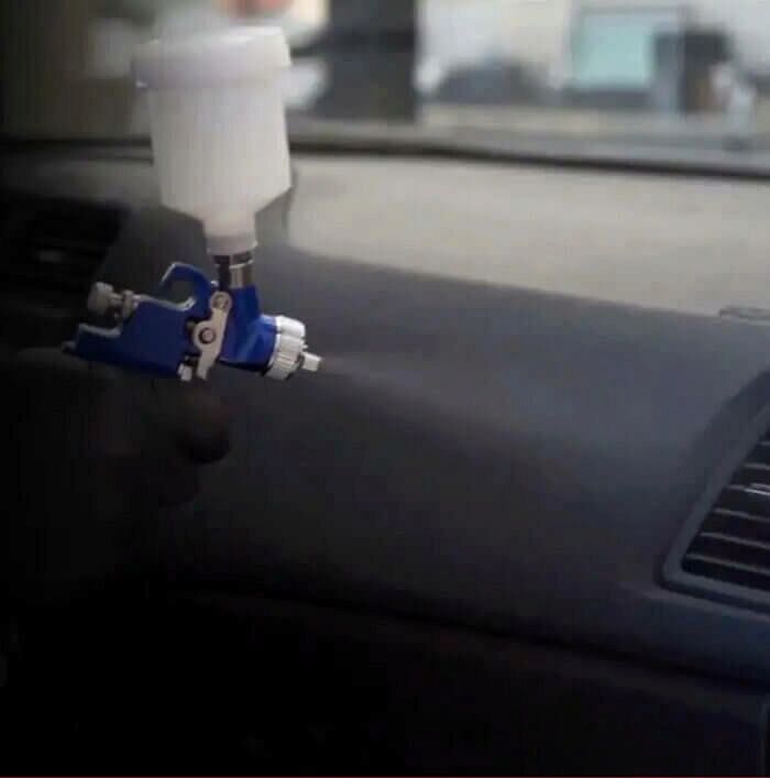 A Mitsubishi technician spraying Diamond Premium Care into the HVAC system of a vehicle