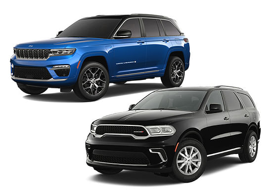 A black Dodge Durango with a blue Jeep Grand Cherokee on a white background.