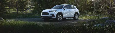 Front driver-side view of the 2026 Honda HR-V LX in Platinum White Pearl shown parked in a forested setting