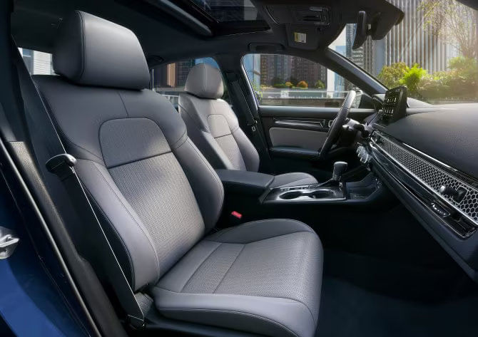 Interior view of the 2025 Honda Civic Hybrid Sport Touring with gray leather-trimmed seats and a modern, ergonomic dashboard.